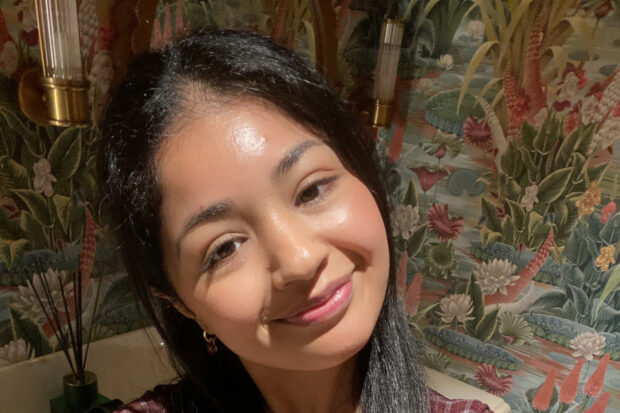 The photo is of Mev, a 2025 Extramural Studies placement student. Mev is smiling at the camera.